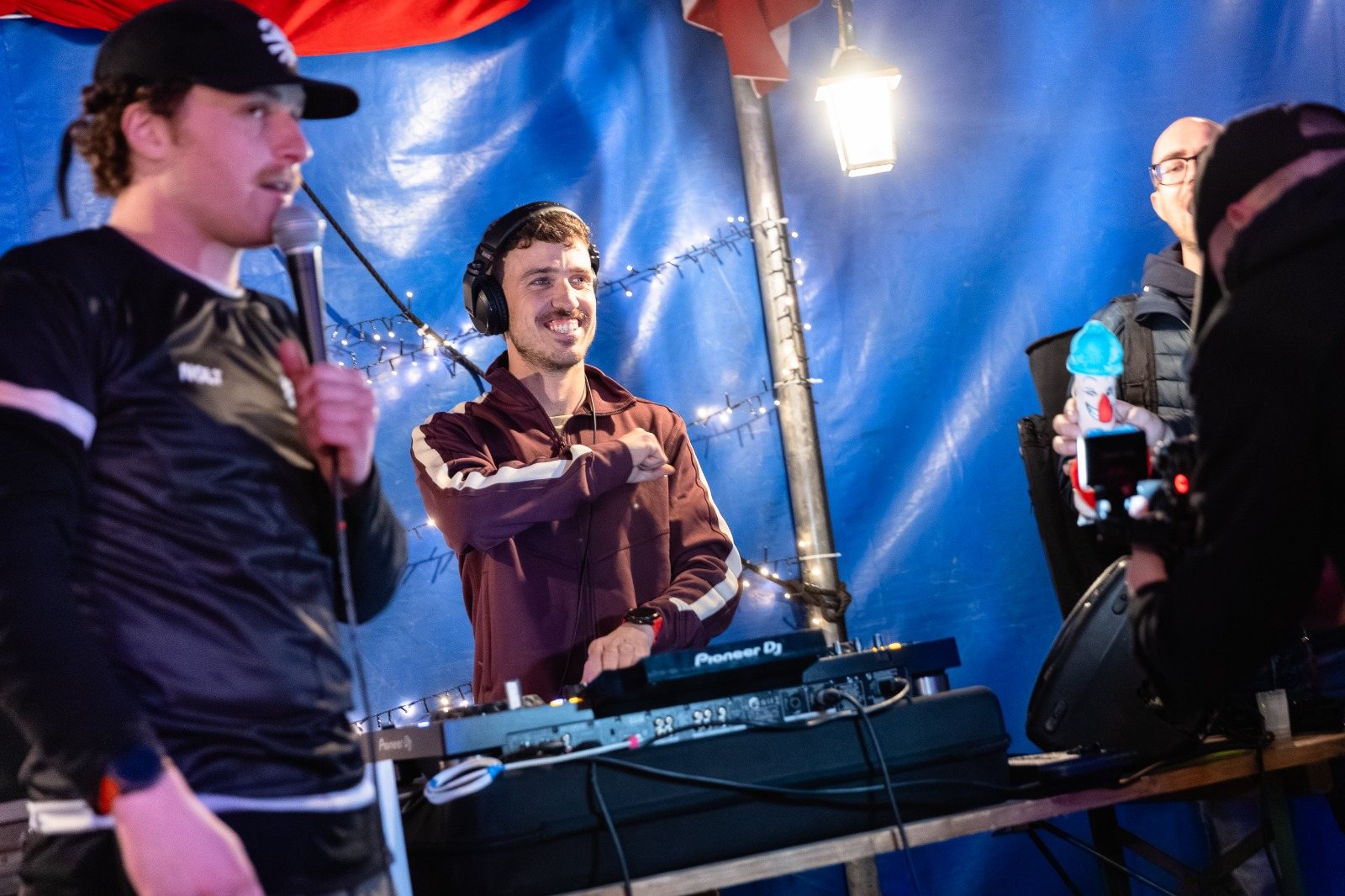 Mathis derrière ses platines, sourire aux lèvres, en soirée extérieure