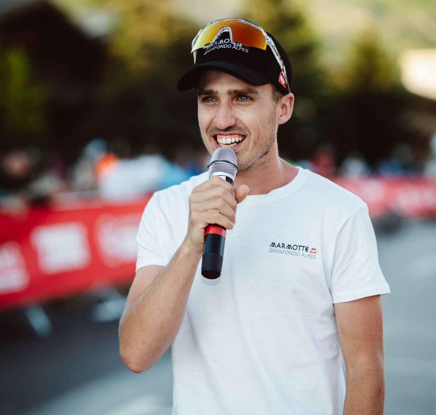 Mathis sourit au micro, lunettes sur la casquette, à Bourg-d’Oisans